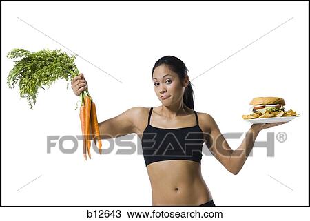 Woman choosing between carrots or hamburger View Large Photo Image Stock Image - Woman choosing between carrots or hamburger. Fotosearch