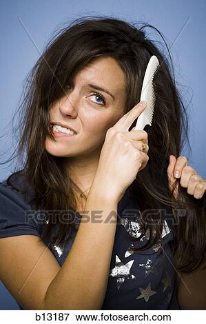 Woman combing her hair View Large Photo Image Stock Photo - Woman combing her hair. Fotosearch
