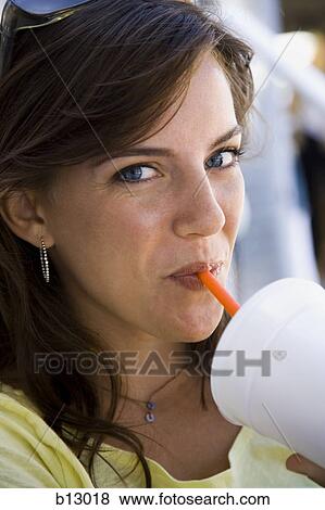 Stock Photo - Woman drinking beverage through a straw. Fotosearch