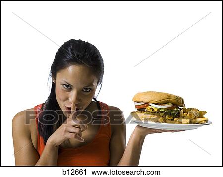 Stock Image - Woman eating a supersized hamburger. Fotosearch