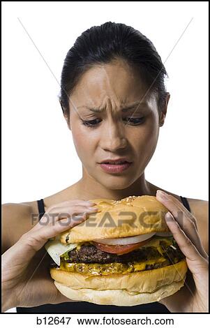 Stock Photo - Woman eating a supersized hamburger. Fotosearch