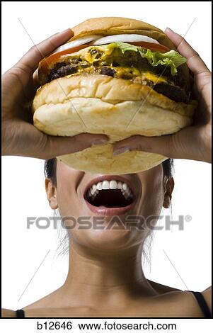 Stock Photograph - Woman eating a supersized hamburger. Fotosearch