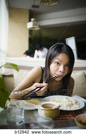 Woman eating at a Chinese food restaurant View Large Photo Image Stock Image - Woman eating at a Chinese food restaurant. Fotosearch