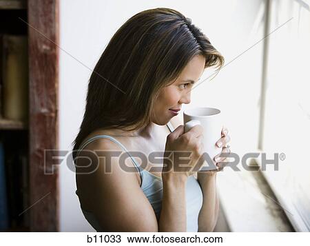 Woman enjoying a mug of coffee View Large Photo Image Stock Image - Woman enjoying a mug of coffee. Fotosearch