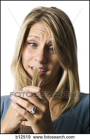 Stock Photo - Woman examining spit ends. Fotosearch