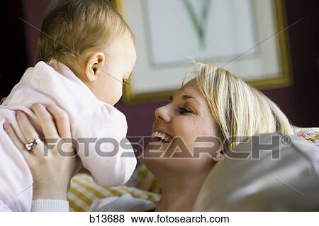 Woman holding baby View Large Photo Image Stock Photo - Woman holding baby. Fotosearch