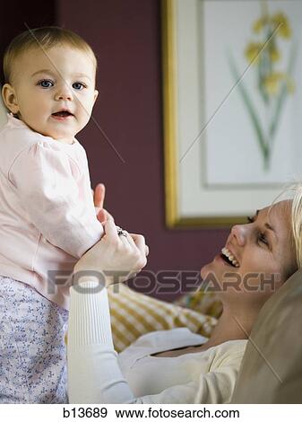 Woman holding baby View Large Photo Image Stock Photo - Woman holding baby. Fotosearch