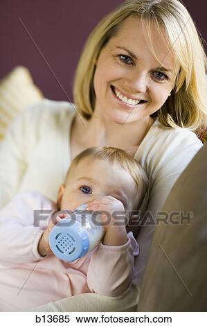 Woman holding baby with bottle View Large Photo Image Stock Photography - Woman holding baby with bottle. Fotosearch