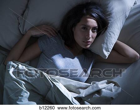 Stock Image - Woman in bed in the dark. Fotosearch