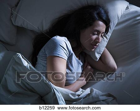 Stock Photo - Woman in bed in the dark. Fotosearch