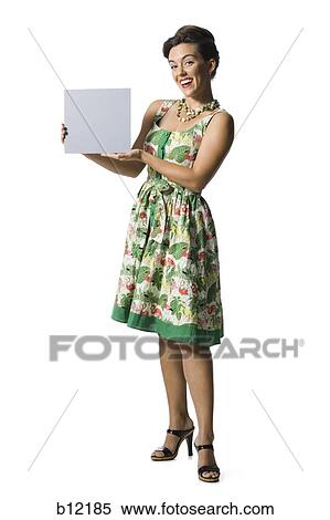 Stock Photography - Woman in floral dress holding a blank sign. Fotosearch