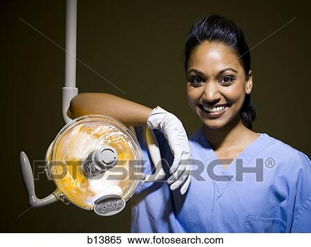 Stock Photography - Woman in nurses uniform leaning on medical light. Fotosearch