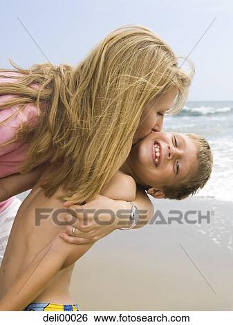 Woman kissing boy on the beach View Large Photo Image Stock Photograph - Woman kissing boy on the beach. Fotosearch