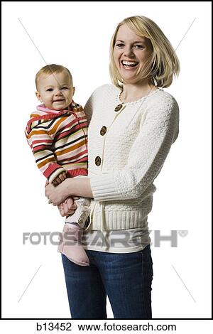 Woman laughing and holding baby girl View Large Photo Image Stock Image - Woman laughing and holding baby girl. Fotosearch