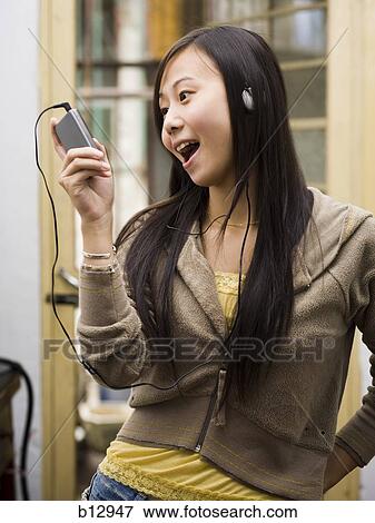 Stock Photo - Woman listening to MP3 player. Fotosearch