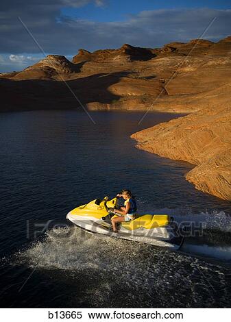 Woman on personal water craft with rock formations View Large Photo Image Stock Photography - Woman on personal water craft with rock formations. Fotosearch
