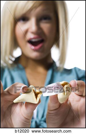 Stock Image - Woman opening fortune cookie. Fotosearch