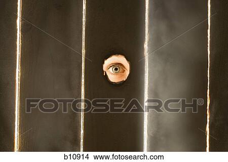 Woman peeping through hole in fence View Large Photo Image Picture - Woman peeping through hole in fence. Fotosearch