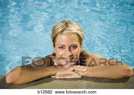 Stock Image - Woman posing in a swimming pool. Fotosearch