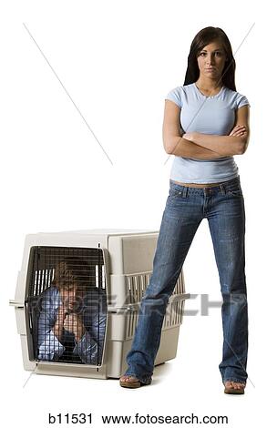 Woman standing by pet crate with man inside View Large Photo Image Stock Image - Woman standing by pet crate with man inside. Fotosearch