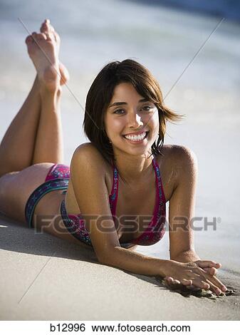 Stock Photograph - Woman sunbathing on beach. Fotosearch