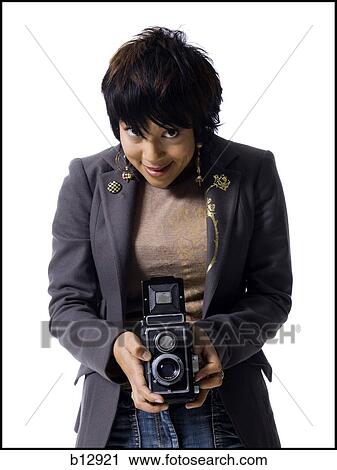 Stock Image - Woman taking a picture with a vintage box camera. Fotosearch