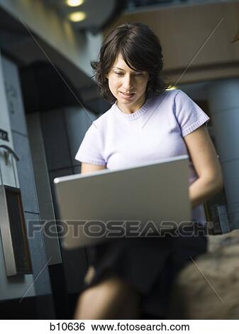 Woman using a laptop View Large Photo Image Stock Photograph - Woman using a laptop. Fotosearch