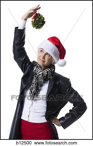 Woman wearing Christmas hat under mistletoe View Large Photo Image Stock Image - Woman wearing Christmas hat under mistletoe. Fotosearch