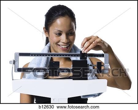 Woman weighing herself on scale View Large Photo Image Stock Image - Woman weighing herself on scale. Fotosearch