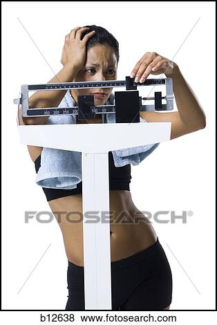 Stock Photo - Woman weighing herself on scale. Fotosearch