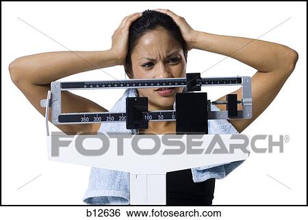Stock Photograph - Woman weighing herself on scale. Fotosearch