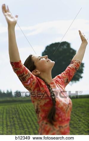 Woman with arms in air basking in sun View Large Photo Image Stock Photo - Woman with arms in air basking in sun. Fotosearch