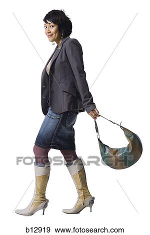 Stock Photo - Woman with knee high boots and handbag. Fotosearch