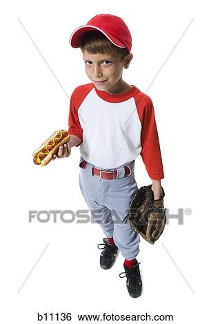 Stock Photograph - Young baseball player holding a hot dog. Fotosearch