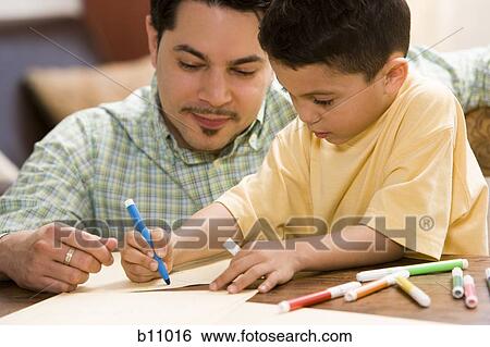Young boy coloring and drawing with father supervising View Large Photo Image Stock Photograph - Young boy coloring and drawing with father supervising. Fotosearch