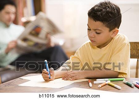 Stock Photography - Young boy coloring and drawing with father supervising. Fotosearch