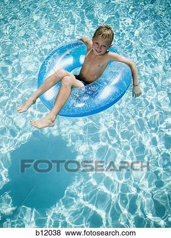 Young boy floating on life ring in swimming pool View Large Photo Image Stock Photo - Young boy floating on life ring in swimming pool. Fotosearch