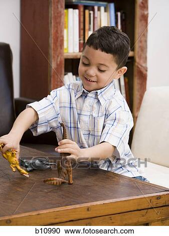 Young boy playing with toy dinosaur figures View Large Photo Image Stock Image - Young boy playing with toy dinosaur figures. Fotosearch