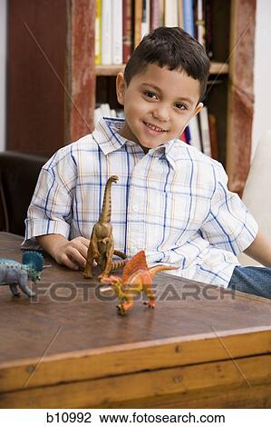 Young boy playing with toy dinosaur figures View Large Photo Image Stock Image - Young boy playing with toy dinosaur figures. Fotosearch