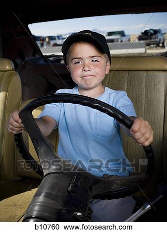 Stock Image - Young boy pretending to drive. Fotosearch