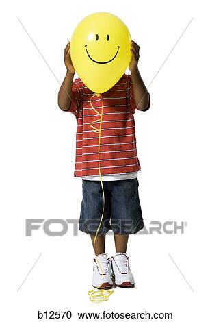 Young boy with happy face balloon View Large Photo Image Stock Image - Young boy with happy face balloon. Fotosearch