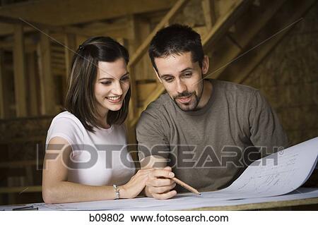 Young couple discussing a blueprint View Large Photo Image Stock Image - Young couple discussing a blueprint. Fotosearch
