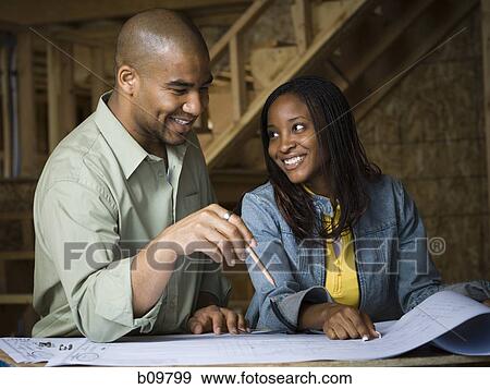 Young couple discussing a blueprint View Large Photo Image Stock Photo - Young couple discussing a blueprint. Fotosearch