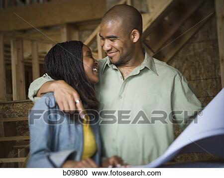Stock Image - Young couple looking at each other and smiling. Fotosearch