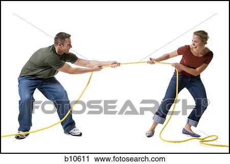 Stock Image - Young couple playing tug-of-war. Fotosearch