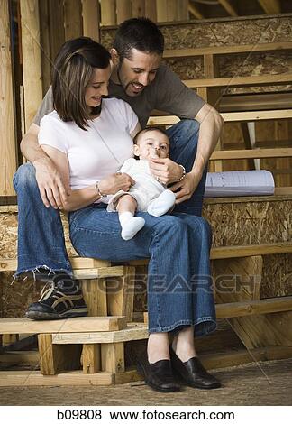 Young couple sitting with their son View Large Photo Image Stock Photo - Young couple sitting with their son. Fotosearch