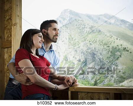 Young couple standing in a balcony View Large Photo Image Stock Image - Young couple standing in a balcony. Fotosearch