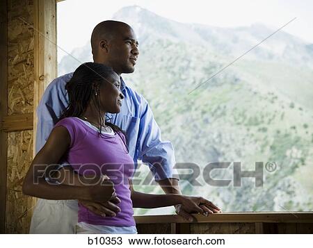 Young couple standing in a balcony View Large Photo Image Stock Image - Young couple standing in a balcony. Fotosearch