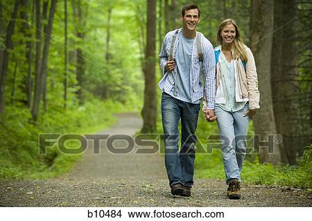 Young couple walking and holding hands View Large Photo Image Picture - Young couple walking and holding hands. Fotosearch