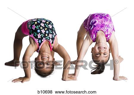 Young female gymnasts bending backwards View Large Photo Image Stock Photo - Young female gymnasts bending backwards. Fotosearch